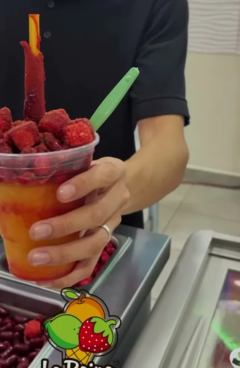 Diablito servido en vaso con fruta roja, jarabe y una tira de tamarindo.